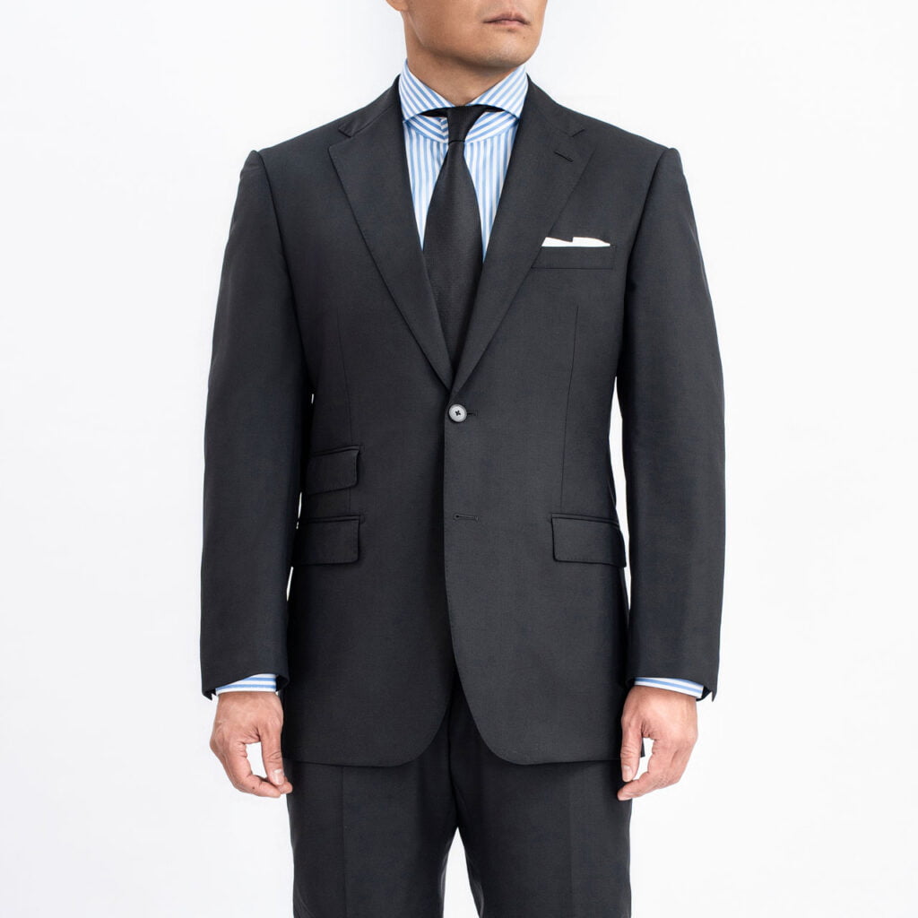 A man in a Black Blazer, Super 120's Wool, Vitale Barberis suit and tie.