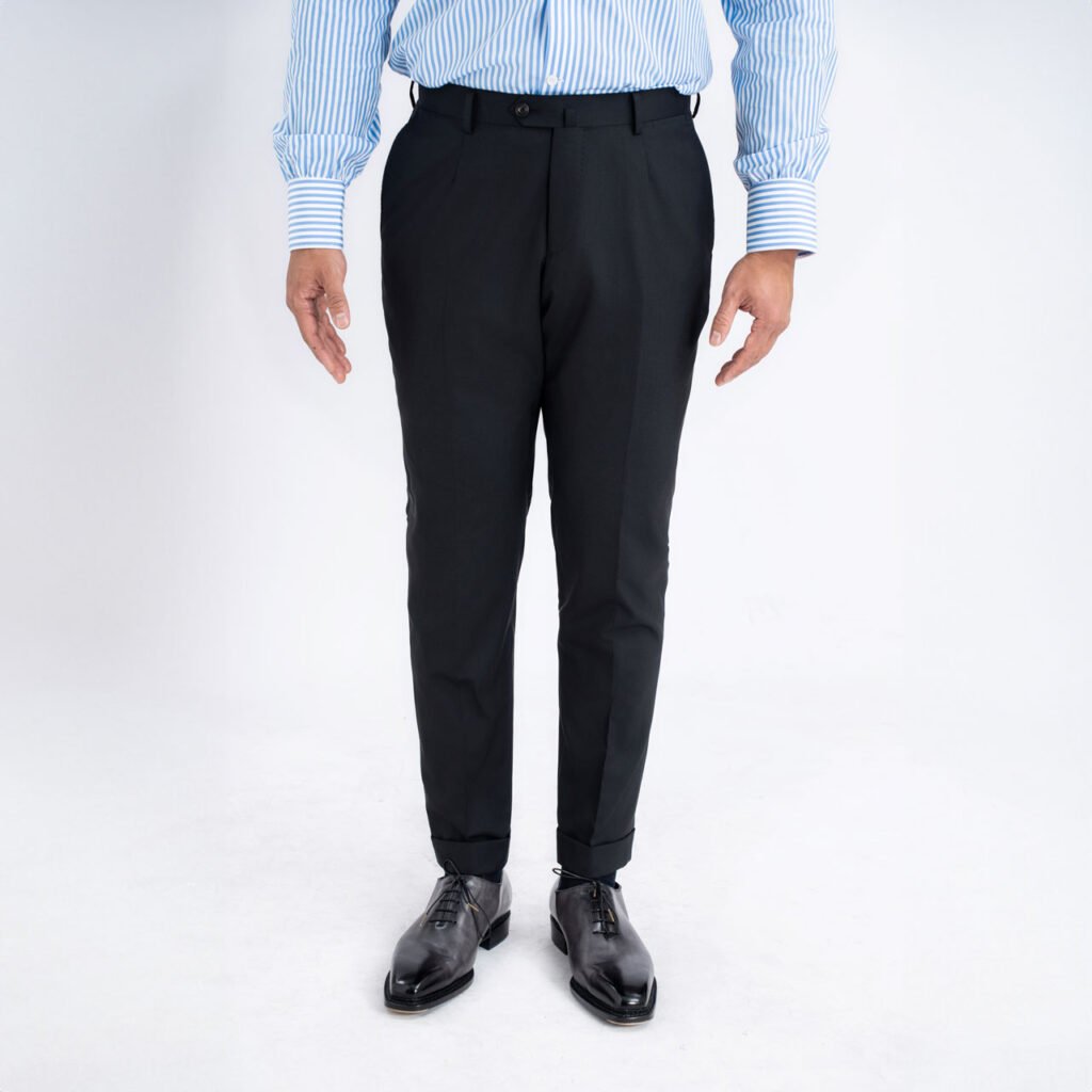 A man wearing black pants and a blue shirt, dressed in a Black Trouser, Super 120's Wool, Vitale Barberis suit.