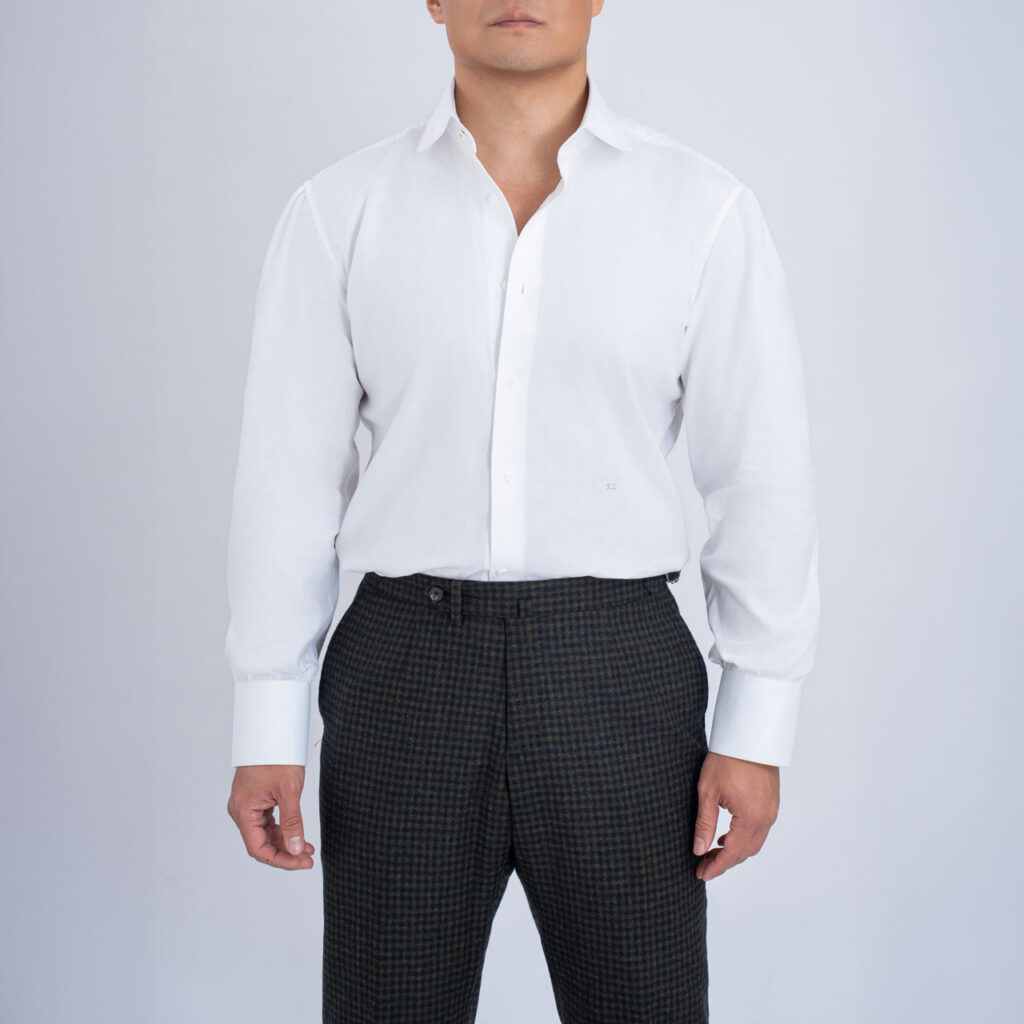 A gentleman in a white shirt and black pants, showcasing impeccable fashion.