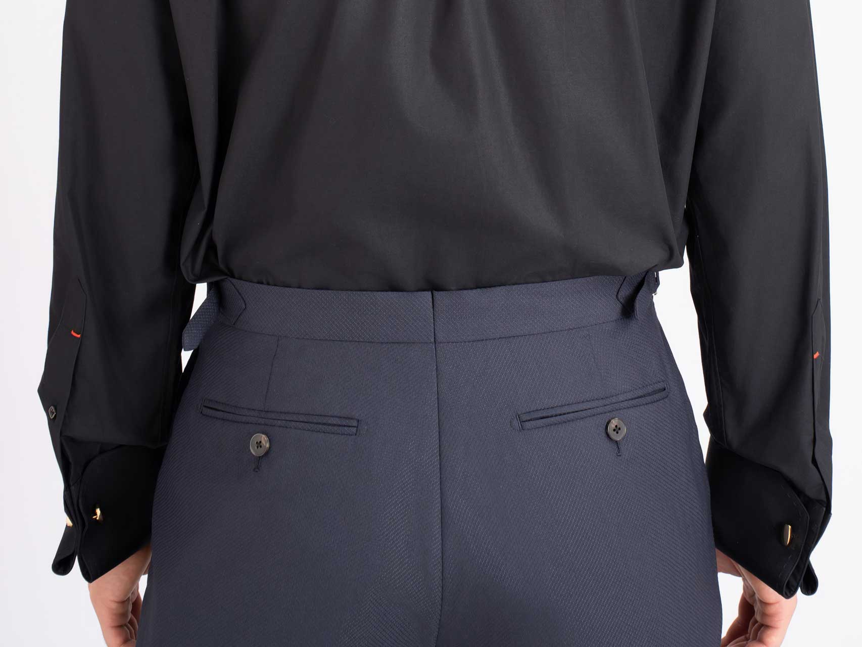 The back view of a woman wearing a black shirt and Midnight blue Tuxedo, Australian Wool/Polyester pants.