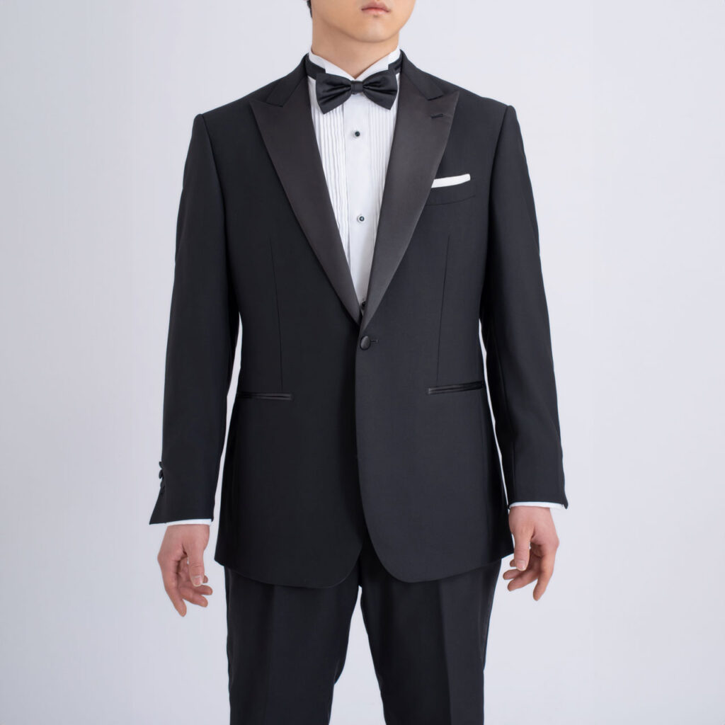 A man wearing a **Black Tuxedo, Australian Wool/Polyester** and bow tie.