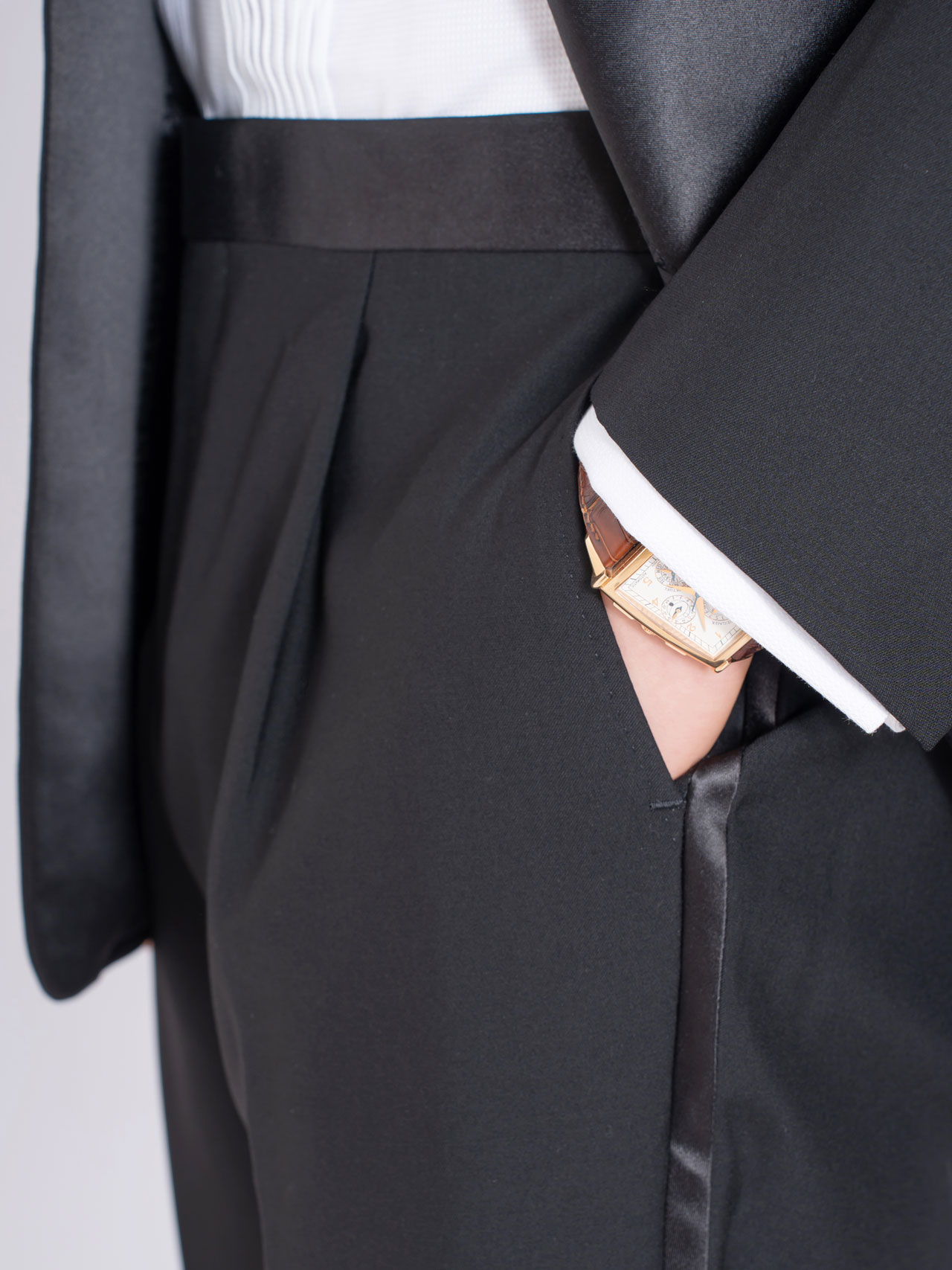 A man in a Black Tuxedo, Australian Wool/Polyester with a watch in his pocket.