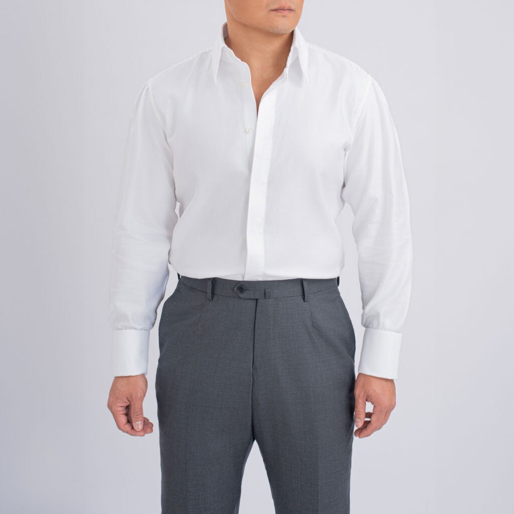 A man in a White smoking shirt, Cotton 80S suit and grey pants.