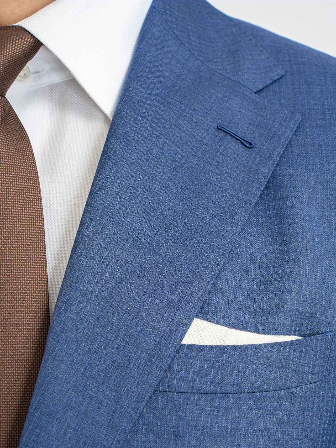 A man in a Light Blue Stripes Suit, Australian Wool, Super 150's with a brown tie.