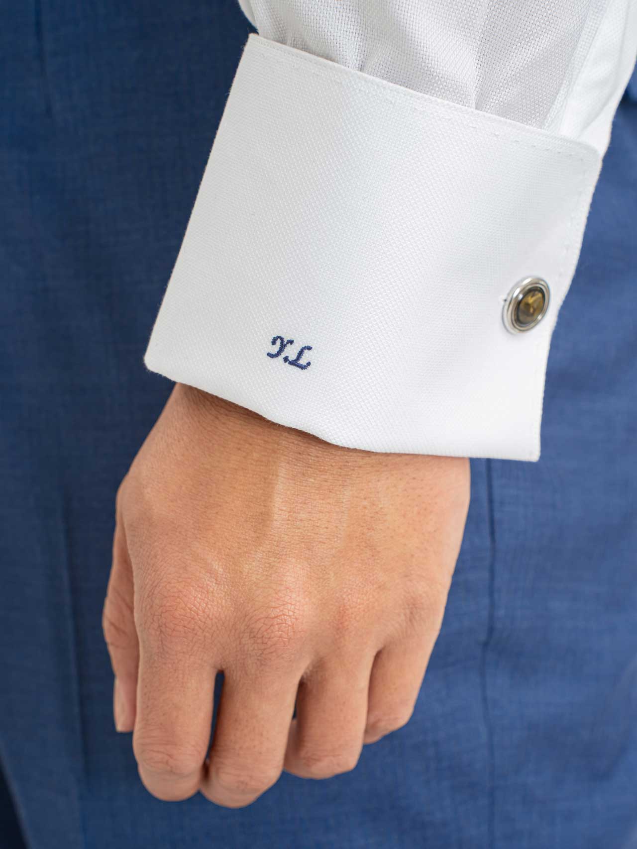 A man wearing cufflinks with his initials on them and a Grey shirt, collar, Cotton 100s.