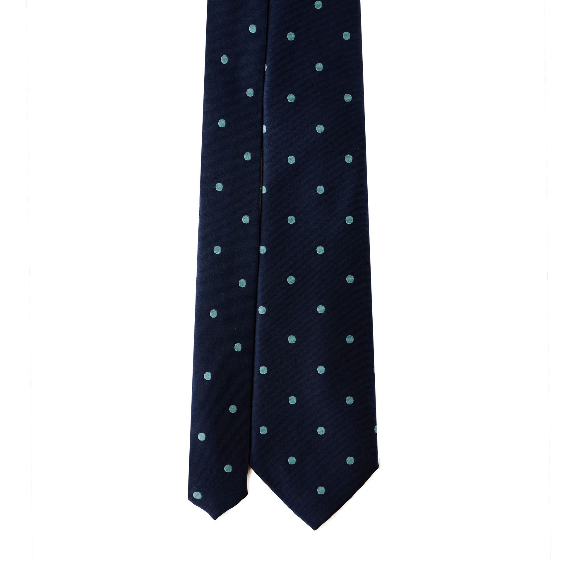 Navy blue tie with light blue polka dots on a white background.