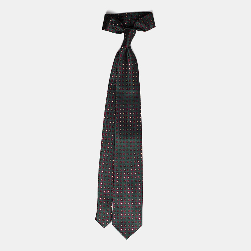 Black necktie with a pattern of small red and white squares on an isolated background.