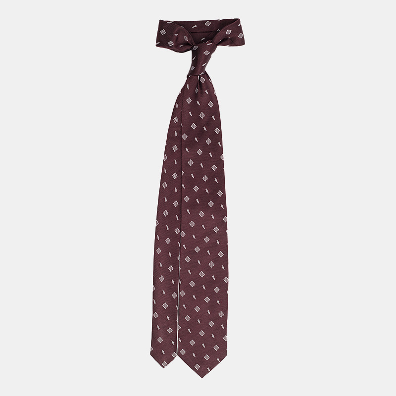 Patterned maroon necktie on a white background.