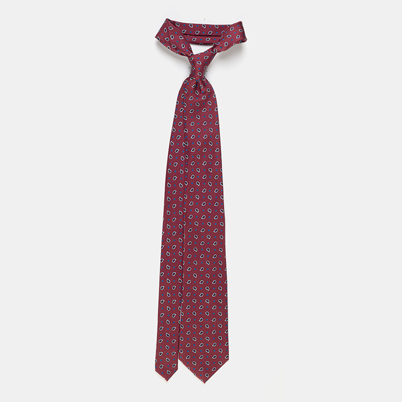 A red Silk tie, n°137 with paisley pattern isolated on a white ceremony shirt background.