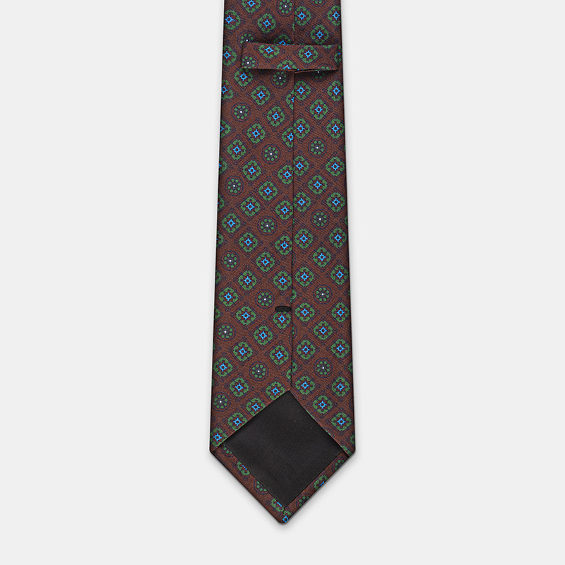 A patterned silk tie with a dark background and multicolored diamond motifs, perfect for pairing with a white ceremony shirt, n°137.