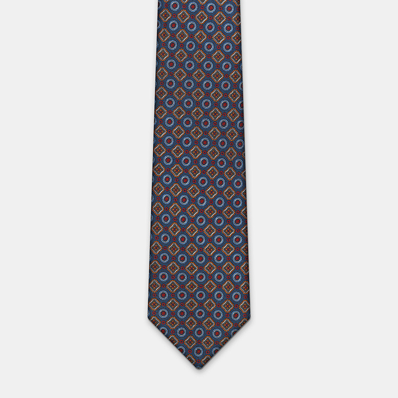 A silk tie, blue with flower n°137 on a white ceremony shirt.