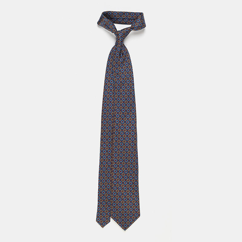 Silk tie, blue with flower n°137 isolated on a white ceremony shirt background.