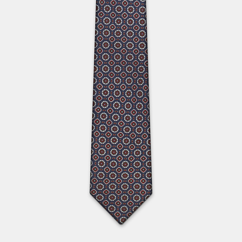 A Blue silk tie with flowers, n°137 with a geometric design against a white background, perfect for complementing a white ceremony shirt.