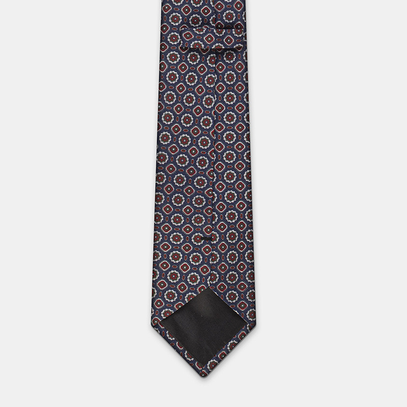 A Blue silk tie with flowers, n°137 with intricate design on a white ceremony shirt.