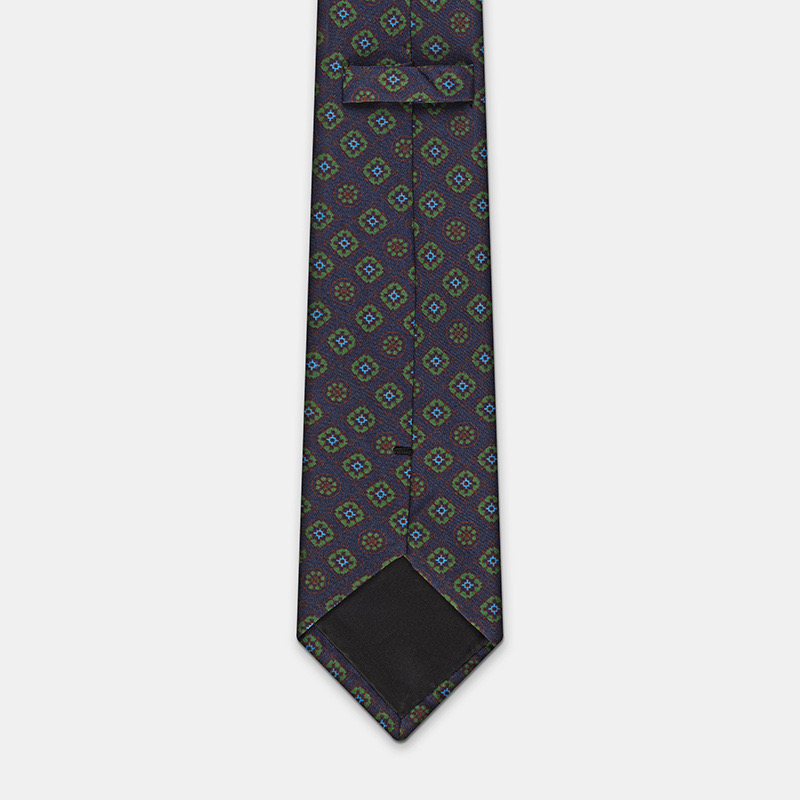 Blue silk tie with flowers, n°137 on a white ceremony shirt background.