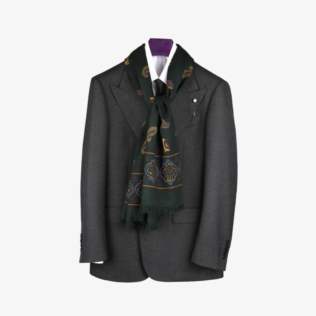 A dark grey suit jacket on a hanger with the Fidema – Wool and silk scarf in deep plum stylishly draped around the collar.