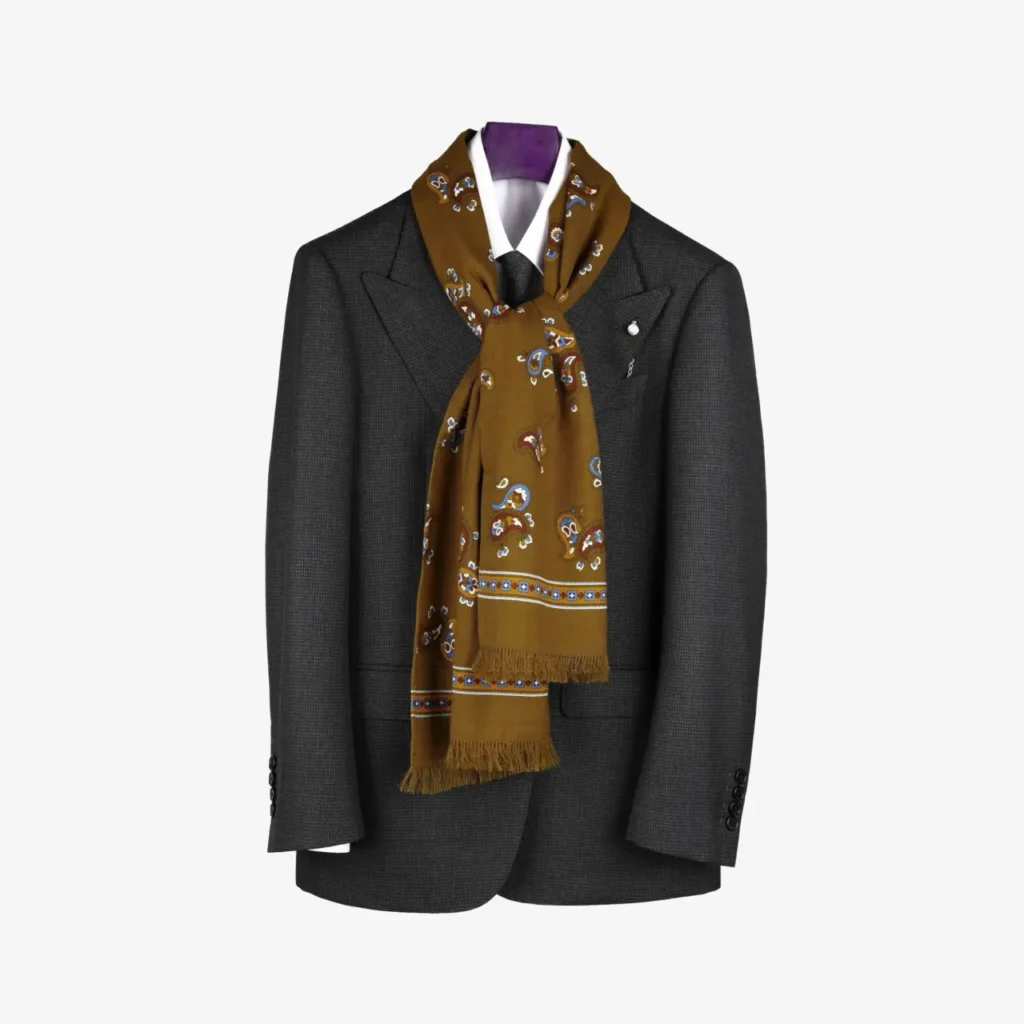 A dark gray suit jacket on a hanger is paired with a white dress shirt and the Noresta – Wool and silk scarf in Burgundy, elegantly draped around the collar.
