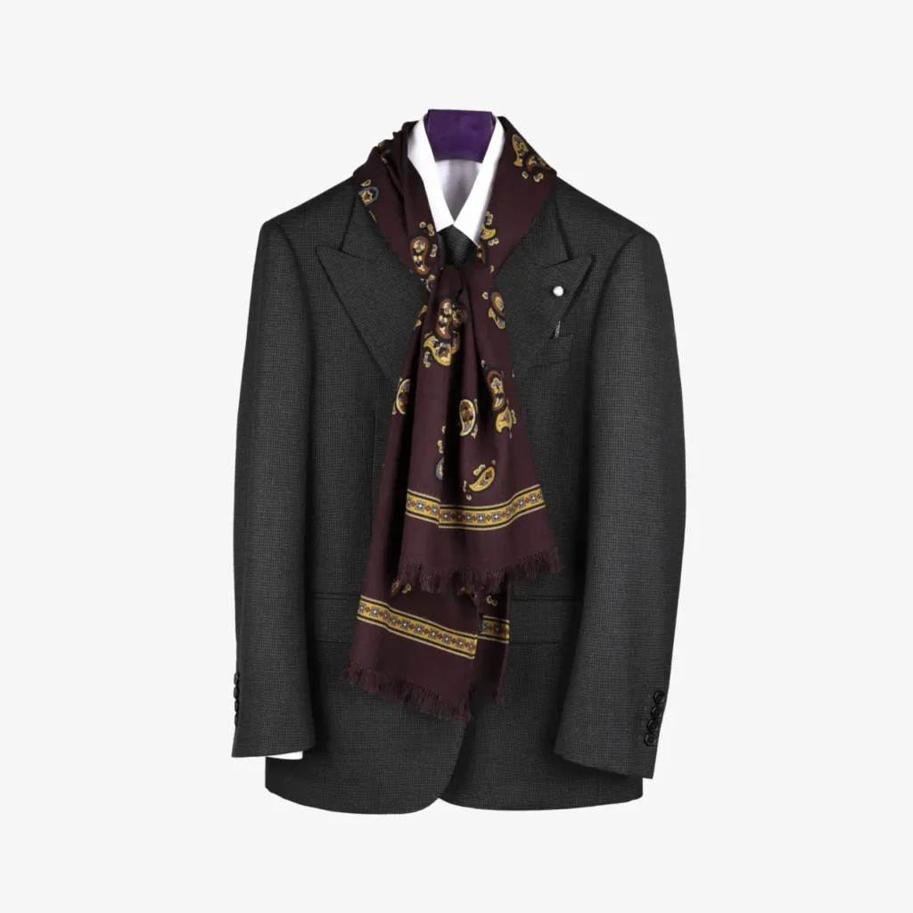 A dark gray suit jacket on a hanger, paired with a white dress shirt and finished with the Fidema – Wool and silk scarf in light grey, stylishly draped around the collar.
