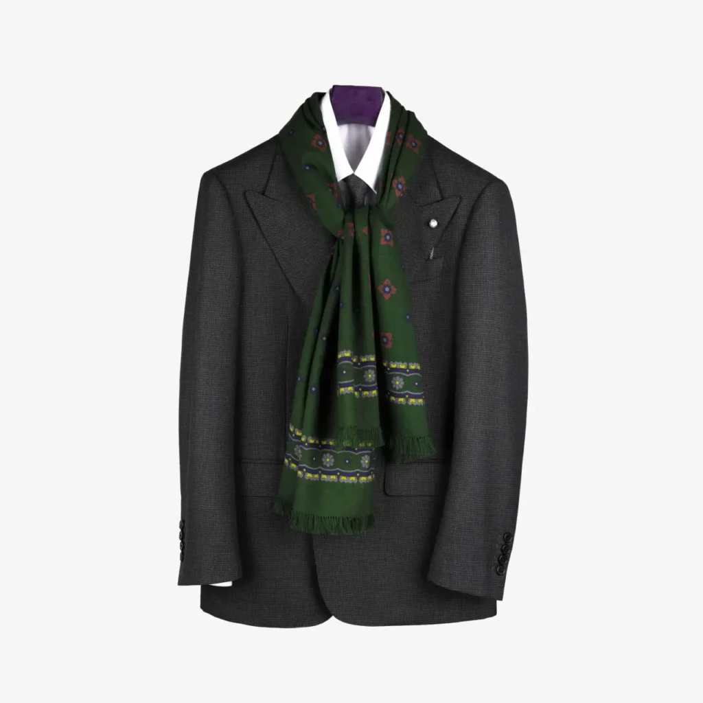 A dark grey suit jacket on a hanger, paired with a white dress shirt and the Kandora – Wool and silk scarf in Navy draped around the collar for an elegant touch.
