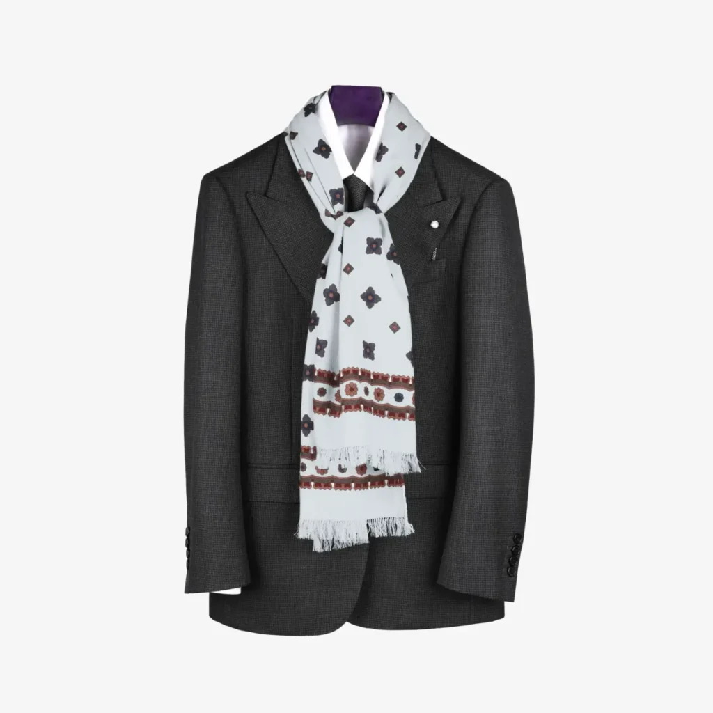 A dark grey suit jacket displayed on a hanger, complemented by the Voluna – Wool and Silk Scarf in Ivory.