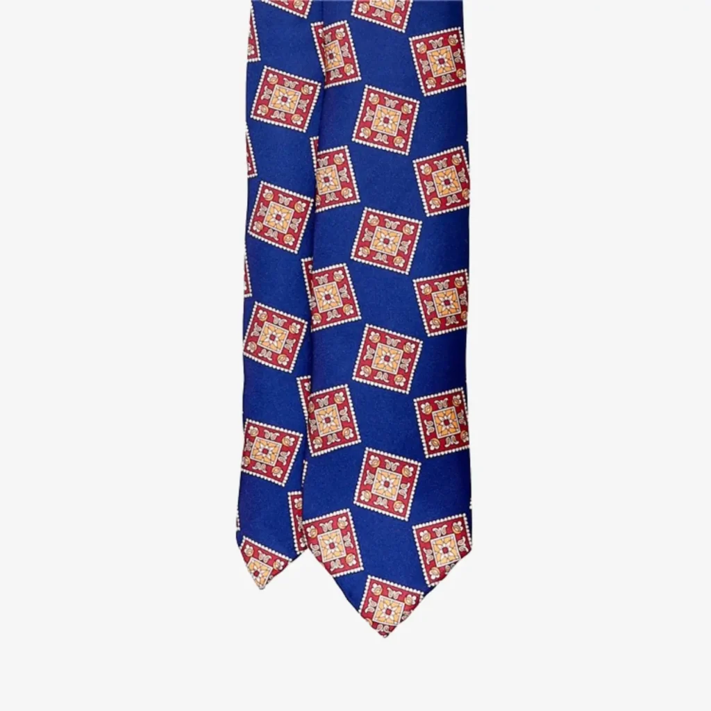 A Blue striped silk tie – Brown (Copy) made of silk, featuring blue stripes and a geometric pattern of red and yellow squares in a repeating design.