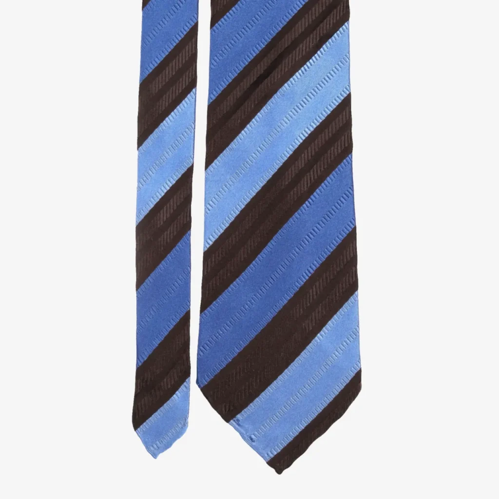 The Wide Stripes Silk Tie – Blue and Brown features bold diagonal blue and brown stripes on a light background for a stylish look.