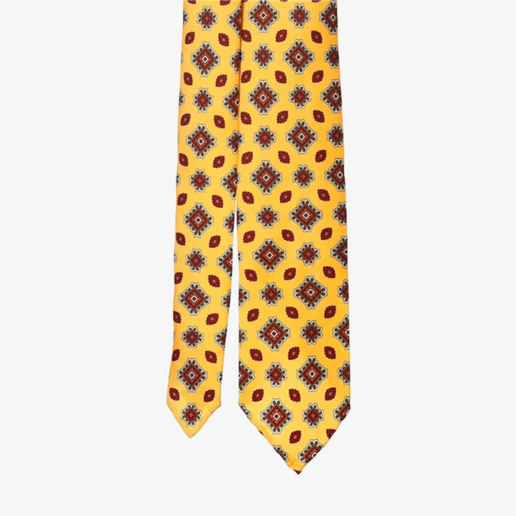 A yellow necktie with a red and blue floral geometric pattern, ideal for pairing with the Blue striped silk tie – Brown (Copy).