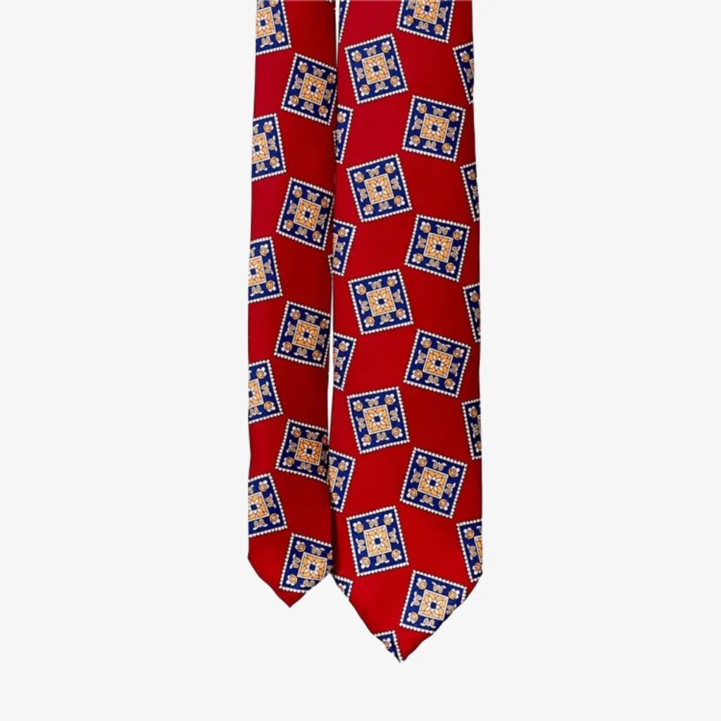 The Geometric Floral Silk Tie – Blue features a repeating blue and yellow square pattern, making it perfect for pairing with classic blue striped silk ties.
