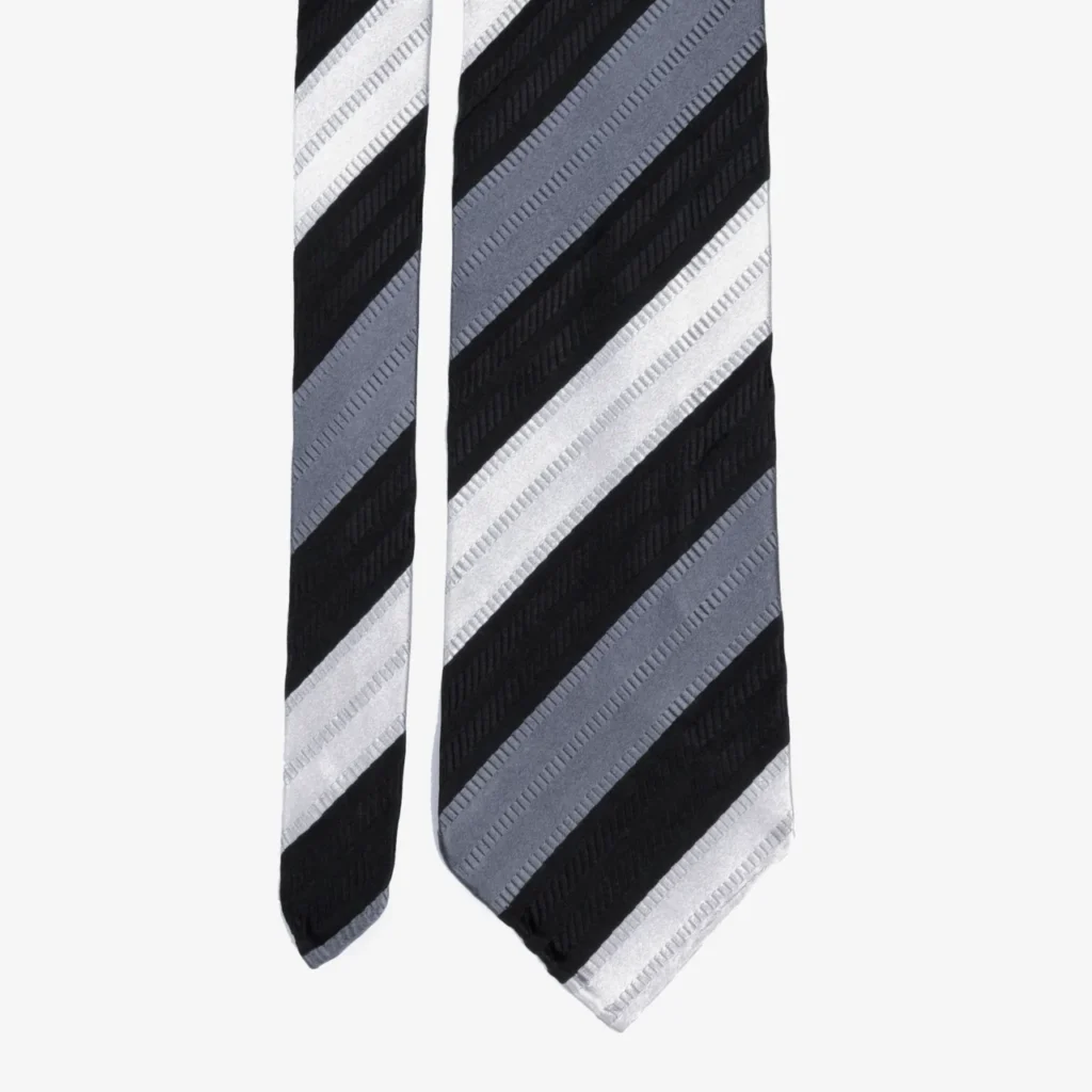 A close-up of the Diagonal stripe silk tie – Forest green, featuring diagonal black, gray, and white stripes on a plain background.