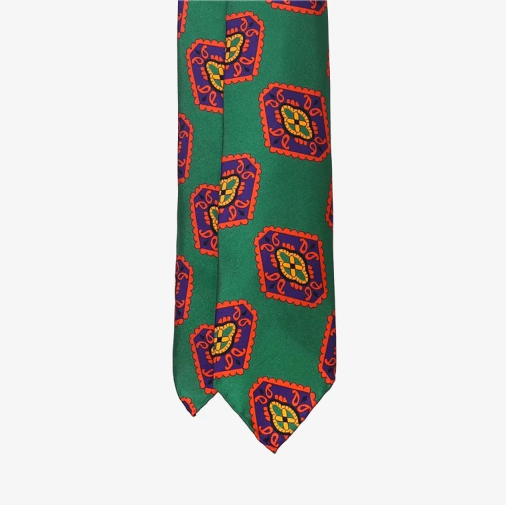 A blue silk necktie featuring a geometric floral pattern, inspired by classic elegance.